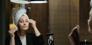 Dziewczyna z ręcznikiem na głowie, zmywająca wacikiem makijaż