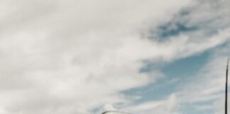 Mały chłopiec siedzący na pasie startowym, w tle samolot.